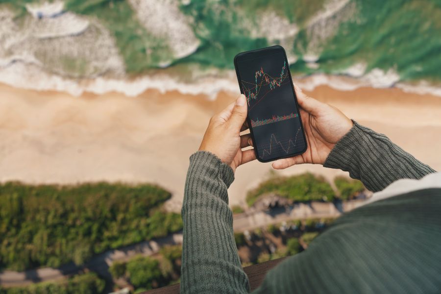 Mulher olhando celular na praia
