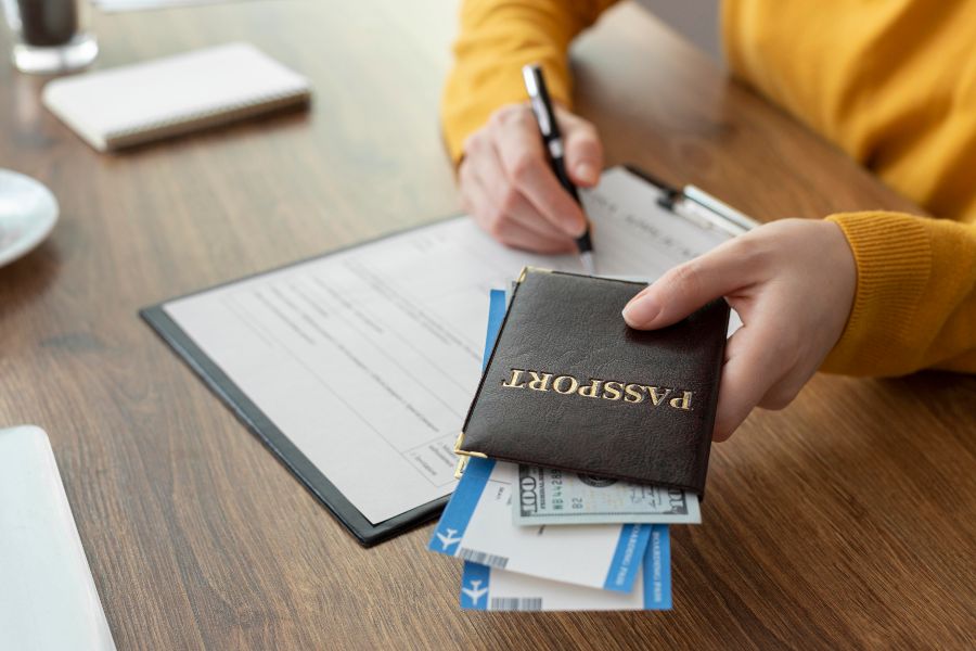 Mulher preenchendo formulário enquanto segura passaporte